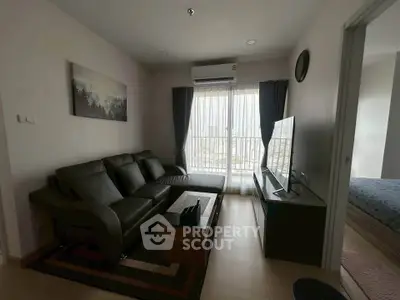 Modern living room with sleek furniture and large window offering natural light.