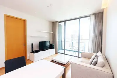 Modern living room with large windows and balcony view in a stylish apartment.