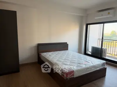 Spacious bedroom with modern design and balcony access in a stylish apartment.