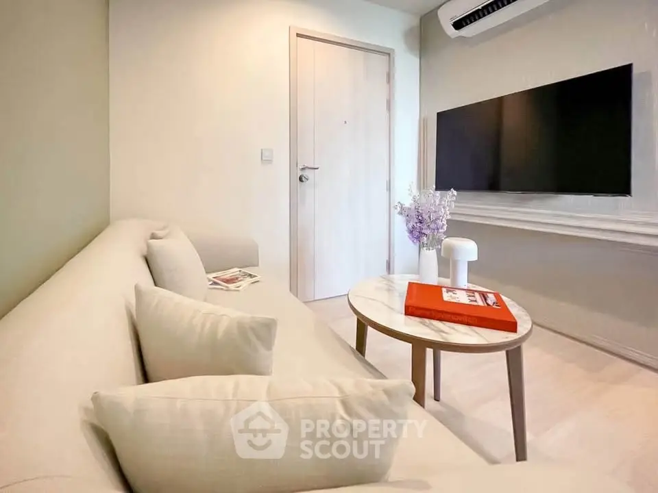 Modern living room with cozy beige sofa, wall-mounted TV, and stylish decor