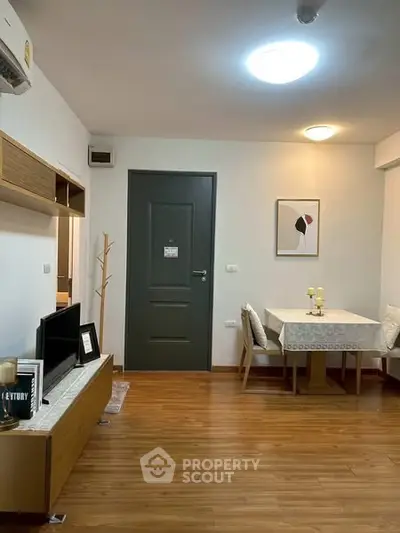 Cozy living room with dining area, wooden flooring, modern decor, and ambient lighting.