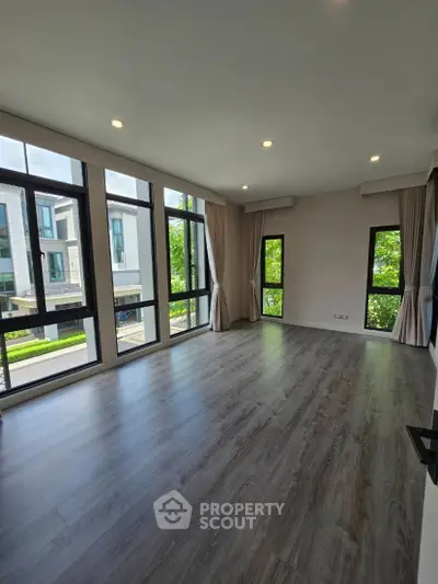 Spacious modern living room with large windows and elegant flooring