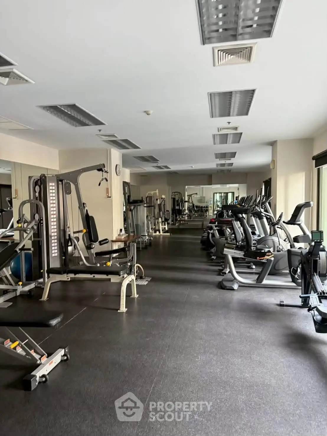 Spacious gym with modern fitness equipment in a residential building