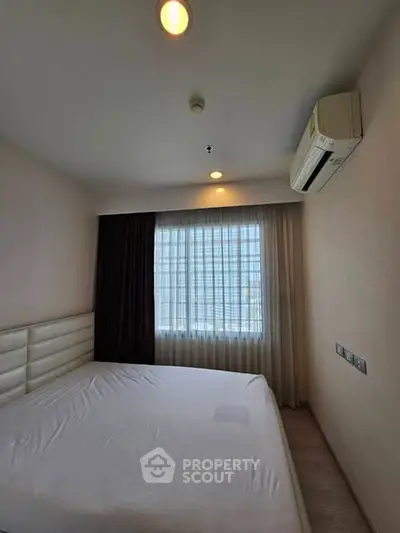 Cozy bedroom with large window and air conditioning unit