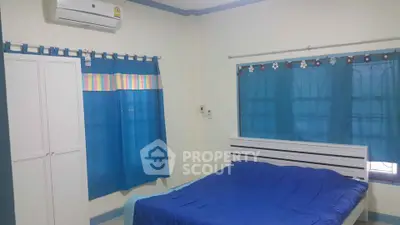 Cozy bedroom with blue accents and air conditioning, perfect for relaxation.