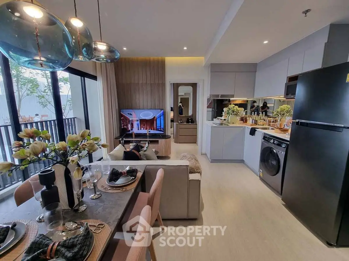 Modern open-layout living room with kitchen, stylish decor, and balcony view.