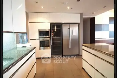Modern kitchen with sleek appliances and granite countertops in luxury home.