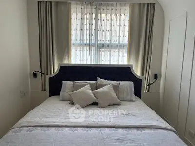 Cozy bedroom with elegant headboard and soft lighting, perfect for relaxation and comfort.