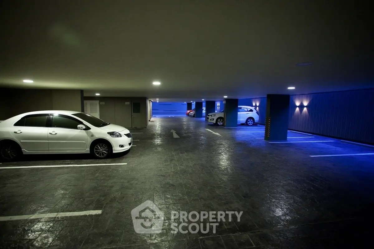 Spacious underground parking garage with modern lighting and multiple parking spaces.