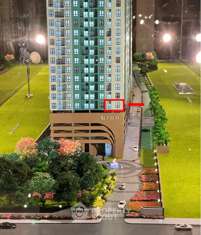 Scale model of modern high-rise building with landscaped surroundings and driveway.