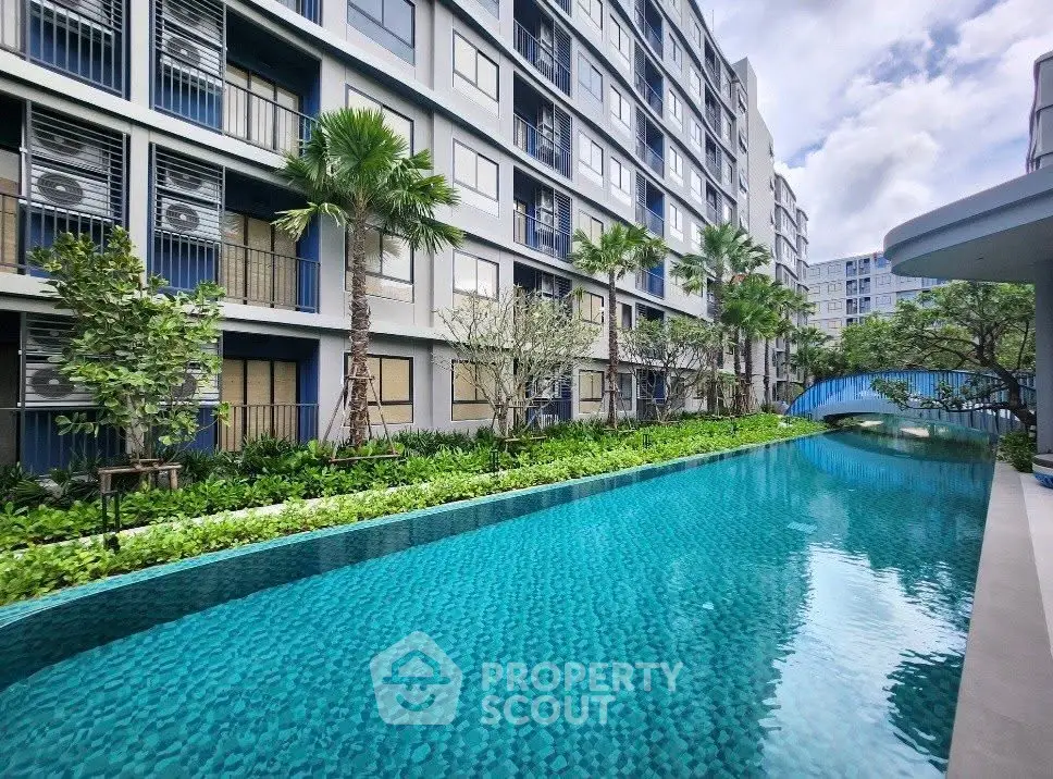 Luxurious apartment complex with stunning pool and lush greenery, perfect for modern living.