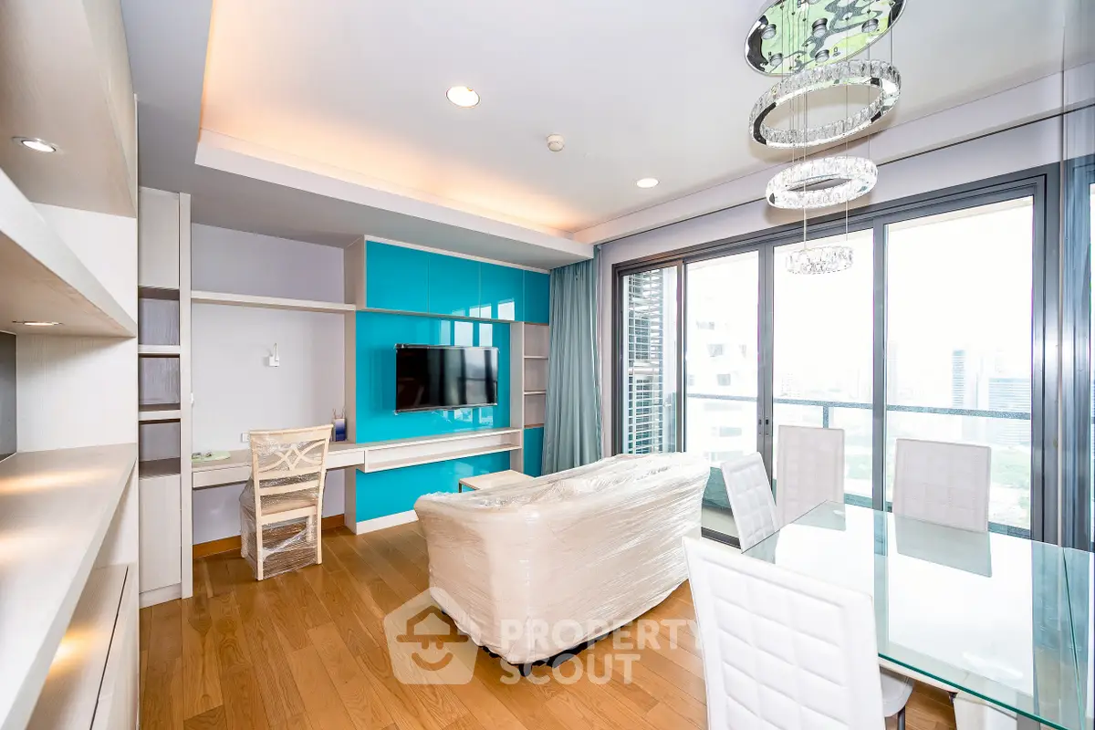 Modern living room with large windows and stylish furniture in a high-rise apartment.