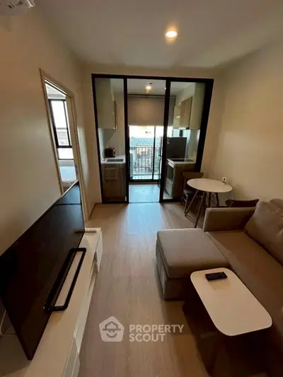 Modern living room with sleek furniture and open kitchen layout, perfect for urban living.