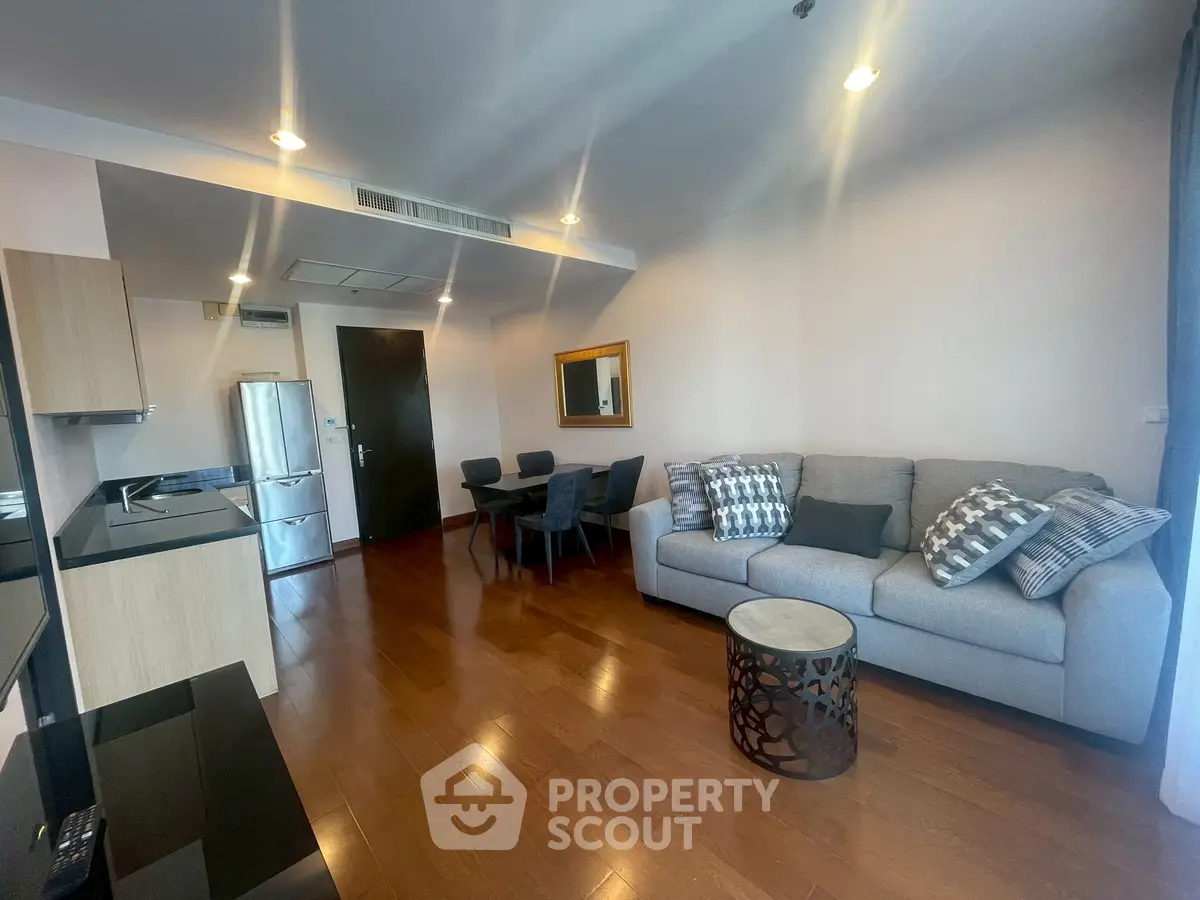 Modern living room with stylish decor and open layout, featuring a cozy sofa and dining area.