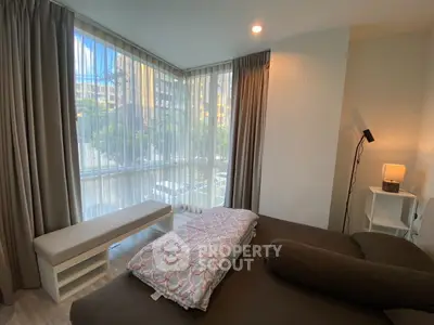 Cozy bedroom with large windows and modern decor, offering a serene view of the outdoors.