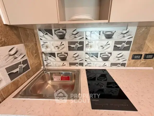 Modern kitchen with sleek induction cooktop and stylish backsplash design.