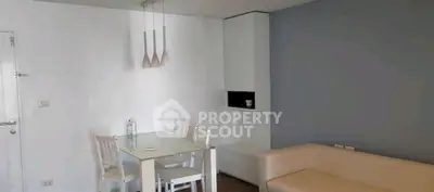 Modern living room with sleek white furniture and glass dining table