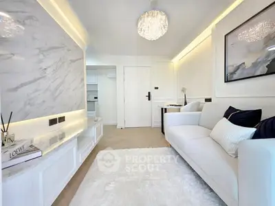 Luxurious modern living room with elegant chandelier and plush white sofa.