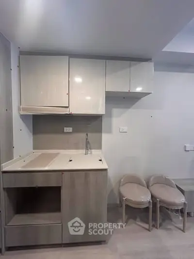 Modern compact kitchen with sleek cabinetry and minimalist design, perfect for urban living spaces.