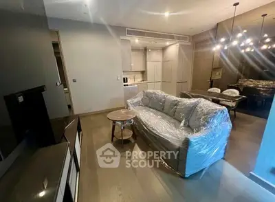 Modern living room with sleek furniture and open kitchen layout in a stylish apartment.
