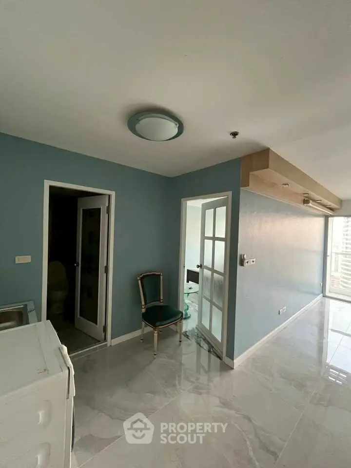 Spacious modern apartment with elegant blue walls and glossy flooring.