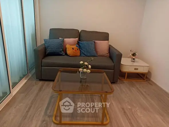 Cozy living room with modern sofa and glass coffee table, perfect for relaxation.