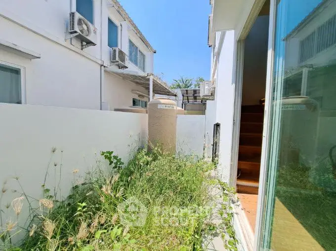 Charming outdoor space with lush greenery and modern architecture, perfect for relaxation.