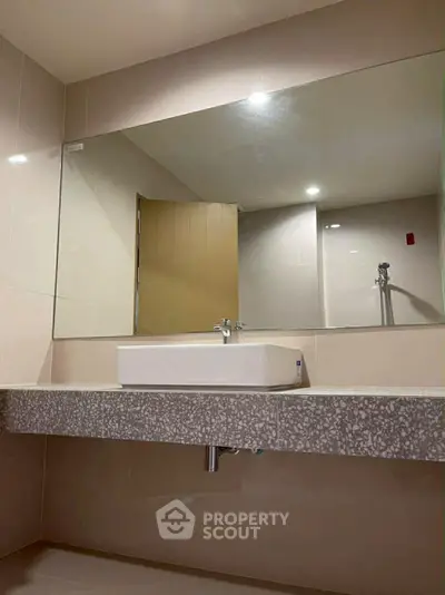 Modern bathroom with sleek design and large mirror, perfect for contemporary living.