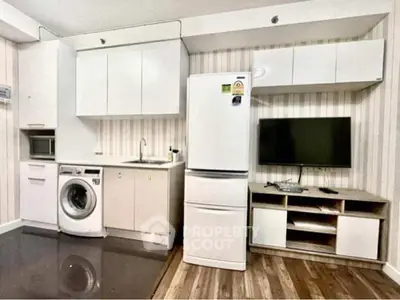 Modern kitchen with appliances including fridge, washing machine, and microwave in a compact layout.