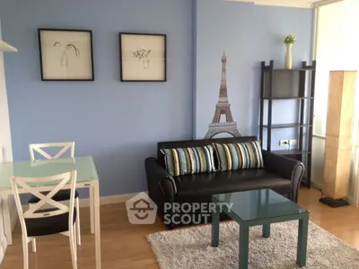 Chic living room with modern decor and Eiffel Tower wall art, featuring a cozy sofa and stylish glass table.