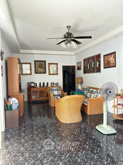 Cozy living room with wicker furniture and ceiling fan, perfect for relaxation.