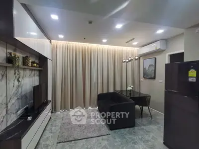 Modern living room with sleek furniture and elegant decor, featuring a cozy black sofa and stylish lighting.