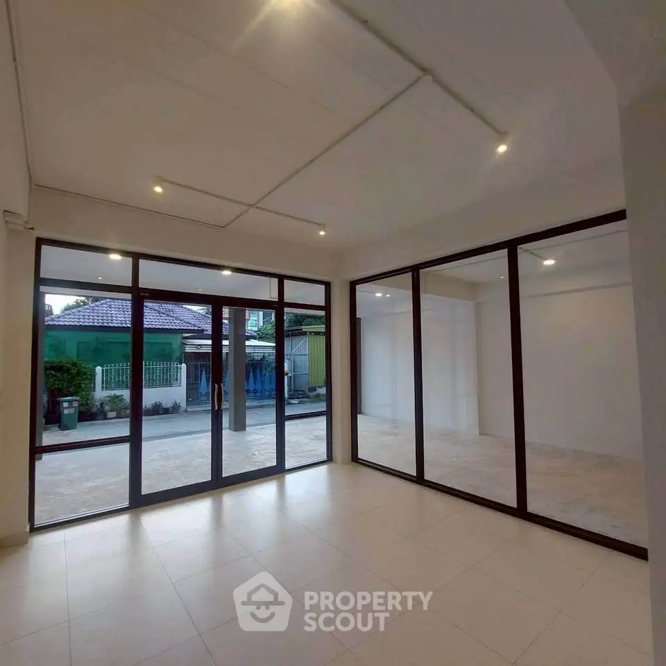 Spacious modern living room with large windows and tiled flooring