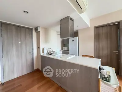 Modern kitchen with sleek design, featuring a central island and wooden flooring, perfect for contemporary living.