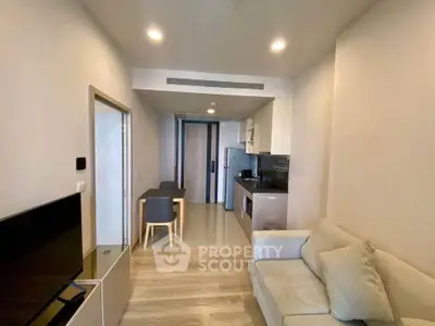 Modern living room with open kitchen layout and cozy seating area in a stylish apartment.