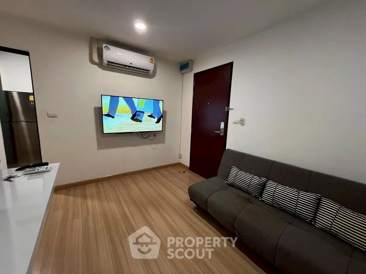 Modern living room with sleek design, featuring a wall-mounted TV and comfortable sofa.