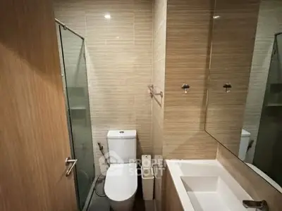 Modern bathroom with glass shower and sleek fixtures in contemporary apartment.