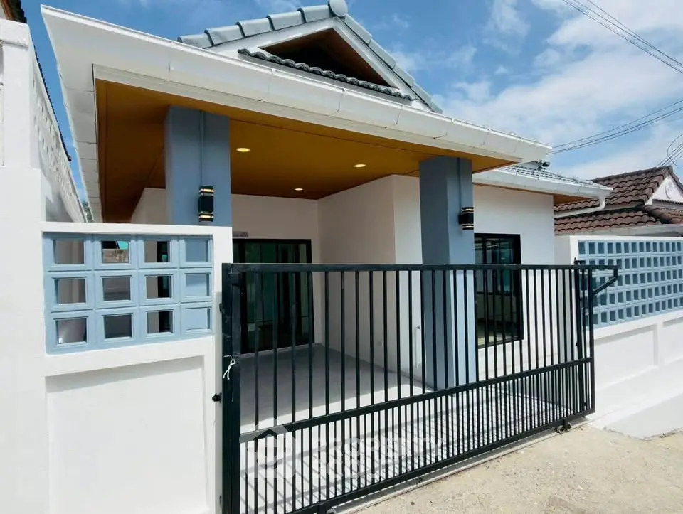 Charming single-story home with modern facade and gated entrance, perfect for family living.