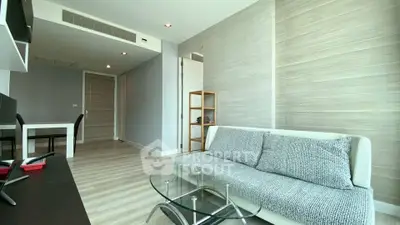 Modern living room with stylish decor and glass coffee table in a bright apartment.