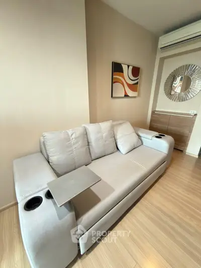 Modern living room with stylish sofa and wall art in a cozy apartment setting.