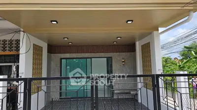 Modern covered patio with sleek lighting and stylish railing, perfect for outdoor relaxation.