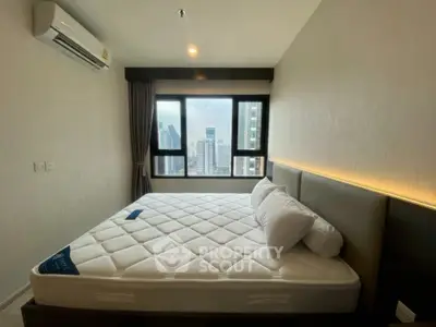 Modern bedroom with city view, featuring a comfortable bed and large windows.
