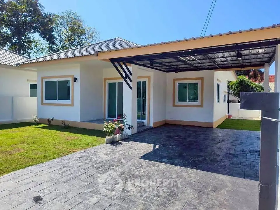 Charming single-story home with modern design, spacious driveway, and lush green lawn in a serene neighborhood.