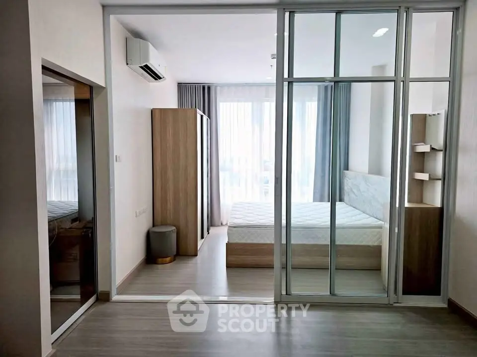 Modern bedroom with glass partition and natural light in stylish apartment