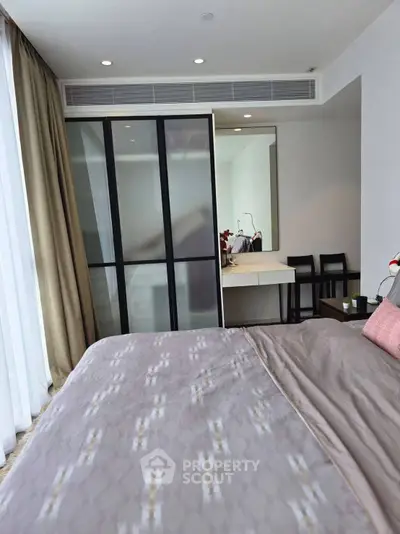 Modern bedroom with stylish decor and large window offering natural light