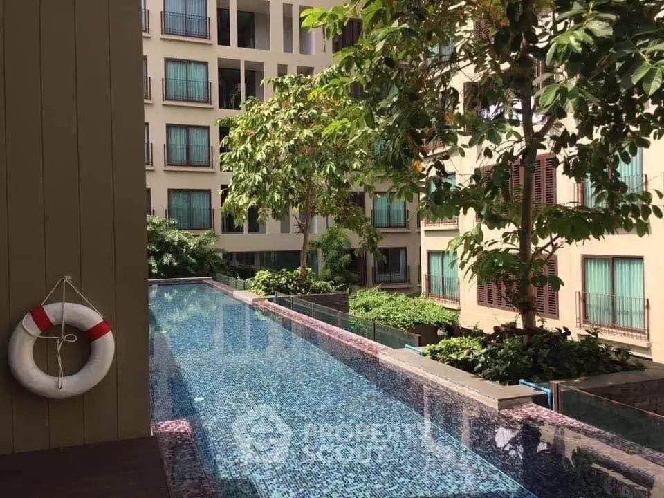 Luxurious condominium with serene pool and lush greenery, perfect for relaxation and modern living.