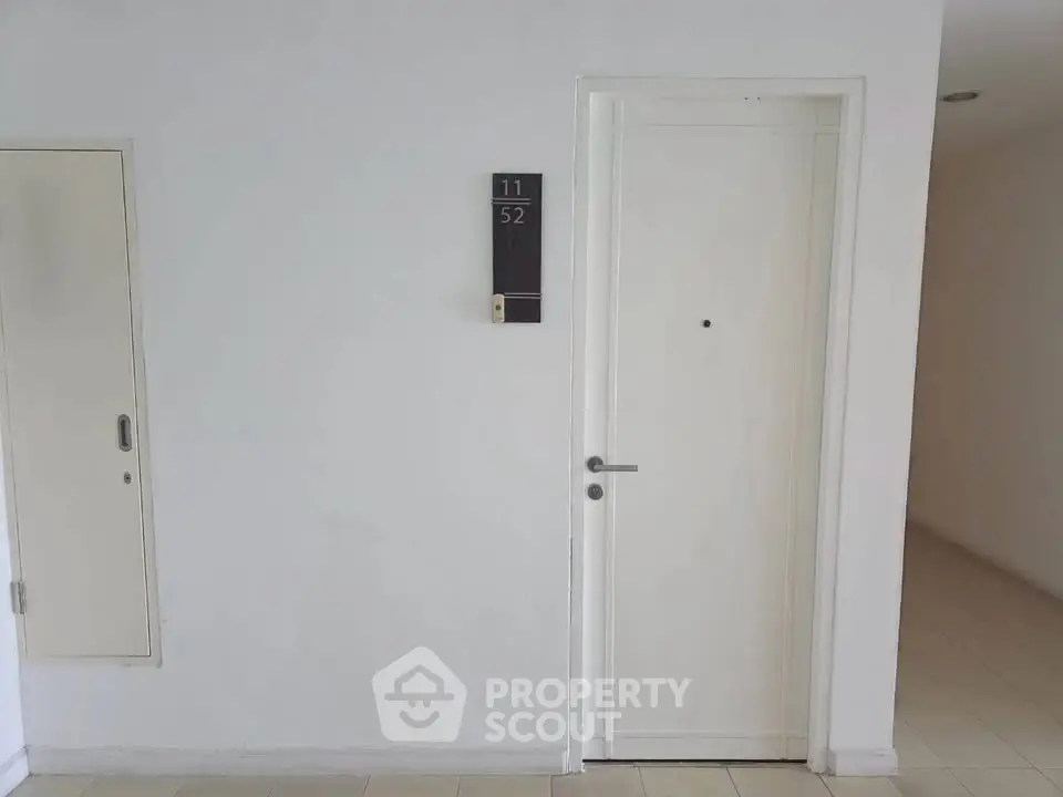 Modern apartment entrance with sleek white door and minimalist design.