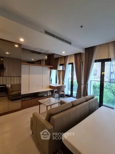 Modern living room with large windows and stylish furniture in a high-rise apartment.