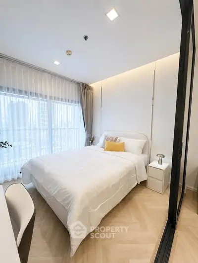 Modern bedroom with large window and elegant decor in a high-rise apartment.