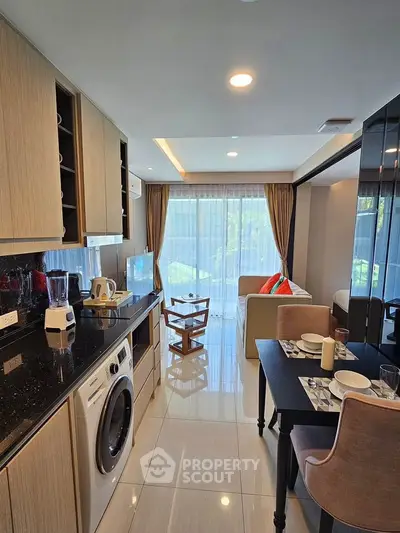 Modern open-layout kitchen and living room with sleek appliances and stylish decor.